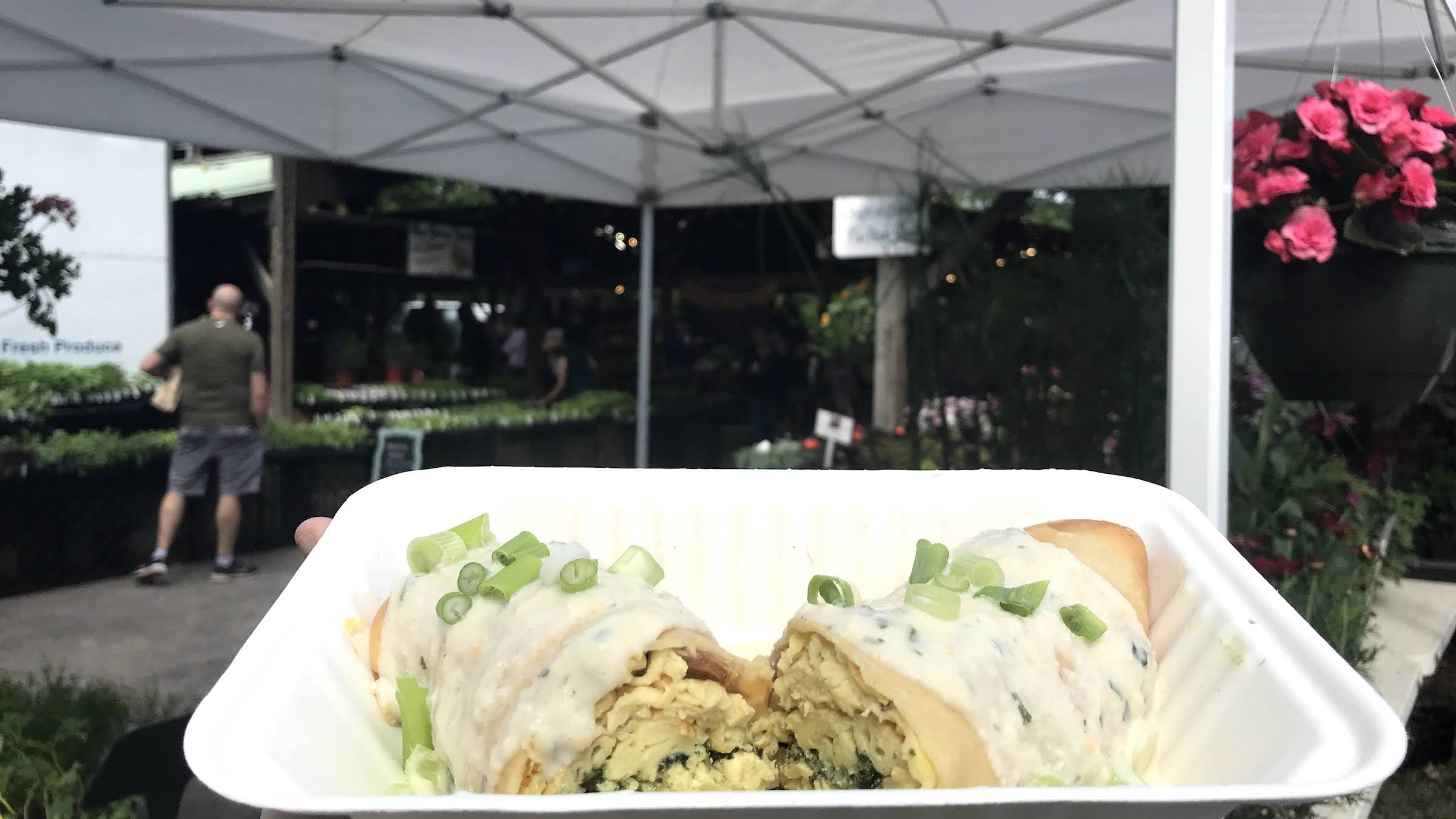 a breakfast crepe against a backdrop of flowers at the Ithaca Farmers Market