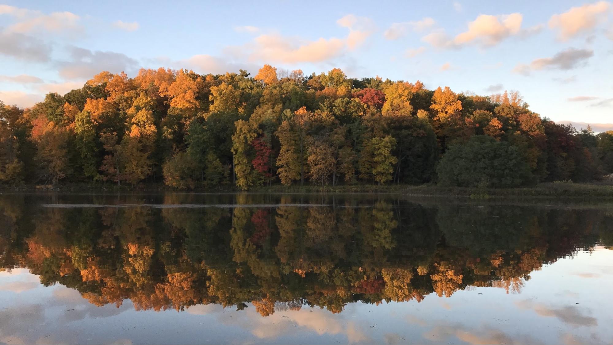 Trees of many autumn colors reflecting off a perfectly still Beebe Lake
